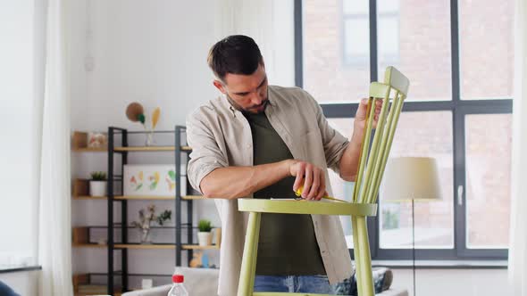 Man with Ruler Measuring Old Wooden Chair at Home