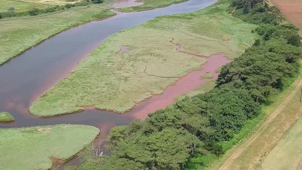 Aerial pan, River Otter and agricultural pastures by a coastal town in Devon, England, STATIC CROP Z