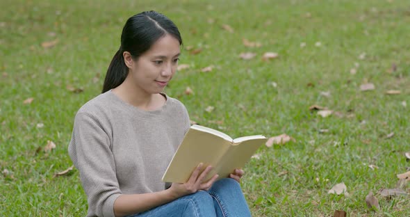 Woman read book on green grass