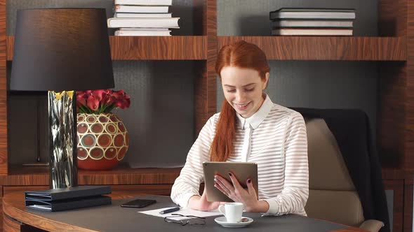 Stylish Redhead Girl Working at Home Office.