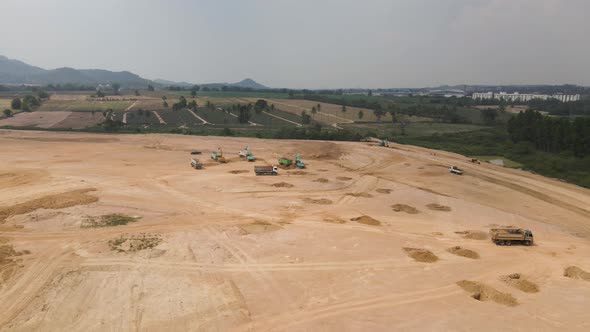 Heavy machinery working on new Construction site on Countryside field, Aerial tracking shot