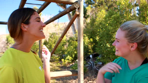 Happy friends interacting with each other during obstacle course