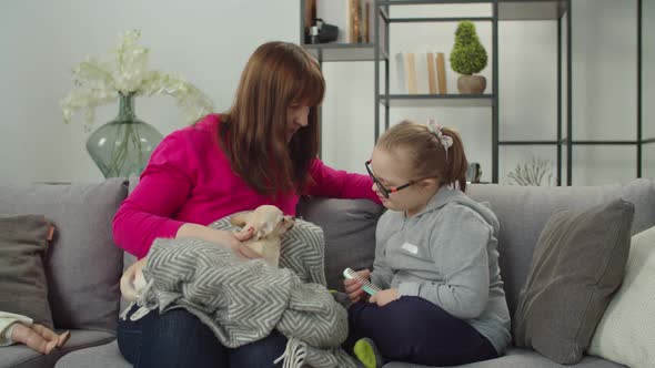 Caring Daughter Combing Mother's Long Hair on Couch