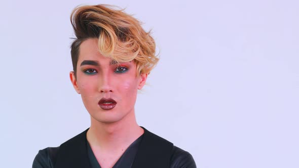 Asian Man with Luxurious Blonde Hair and Gorgeous Makeup in White Wall Studio Background Passion