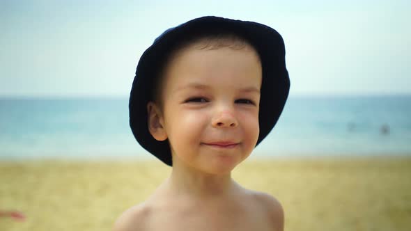 Boy of Two Years Fooled By a Camera on the Beach Near the Oceane