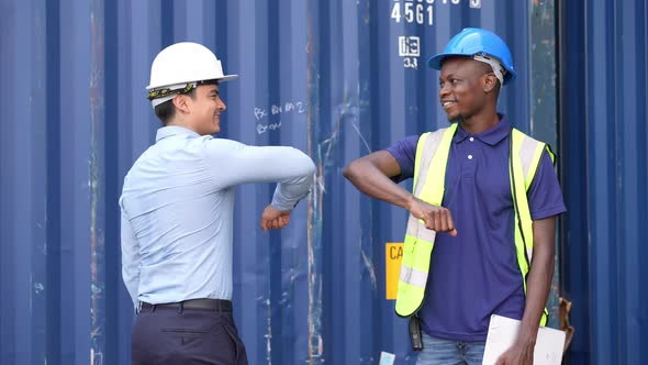 construction site worker and foreman elbow bump greeting at construction site