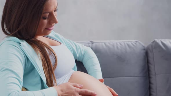 Young pregnant woman is resting at home and expecting a baby.