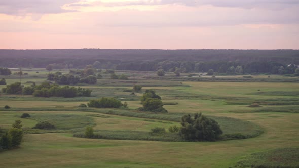 Panoramic View of River Between Fields During Sundown.