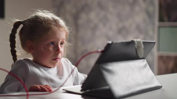 Emotional Girl Watches Video Lesson Via Tablet at Home