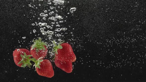 Fresh Strawberry Fruit Dropped Into Water Shot in Super Slow Motion