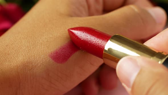 Close-up woman opens red lipstick before makeup. Facial care, makeup application, lipstick.