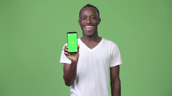 Young Happy African Man Smiling While Showing Phone To Camera