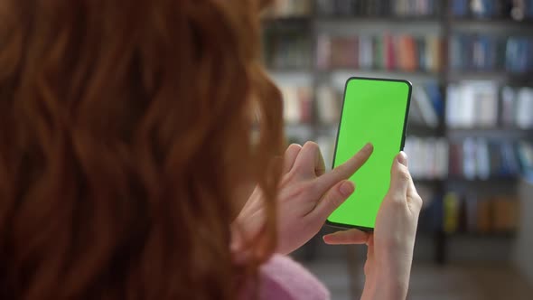 Back View of Woman at Phone with Green Screen for Copy Space alt