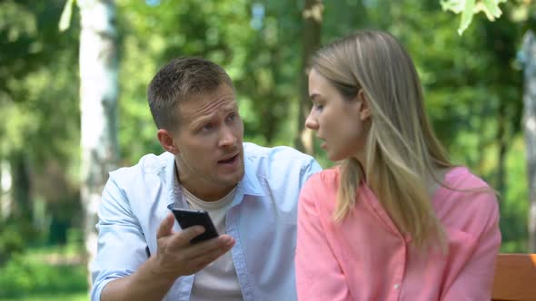 Angry Man Shouting on Wife, Looking Through Messages on Her Phone, Jealousy