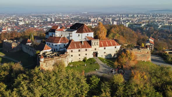 Aerial drone view of The Citadel in Brasov at sunrise, Romania. Medieval fortress on the top of a hi