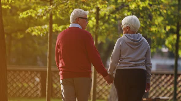 Senior Caucasian Couple Spending Time Together in a Park in the Afternoon Shooting From the Back