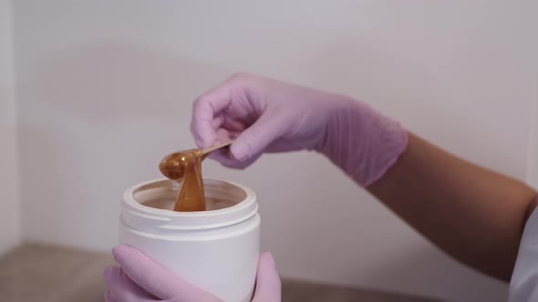 Cropped View of Process of Taking Wax for Beautician Procedure