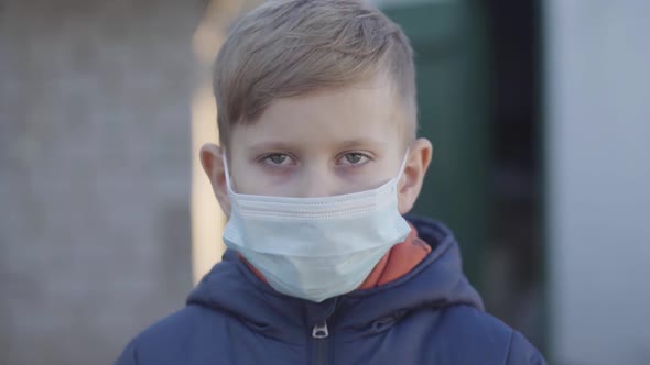 Portrait of Caucasian Little Boy Taking Off Face Mask at the End of Covid-19 Quarantine. Happy