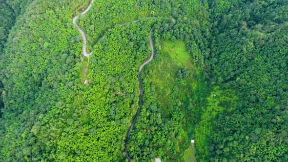 Aerial view of road on mountains and forest.