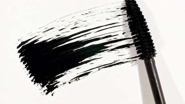 Macro Shot and Slow Motion of a Black Mascara Isolated on White Background