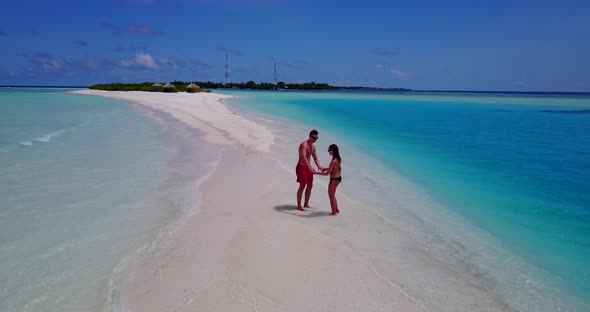 Beautiful boy and girl on honeymoon vacation enjoy life on beach on white sand 4K background