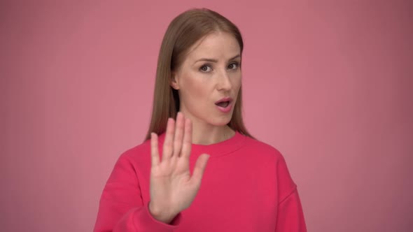 Serious concerned woman making stop gesture showing palm of hand