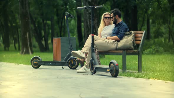 Renewable Energy Transport. Boyfriend And Girlfriend Enjoying Time Together In Park.E-Scooter Riding