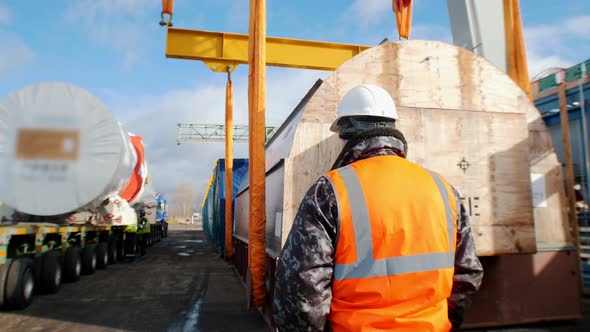 Cargo Shipping - a Man Worker Standing on the Construction Site and Controls the Process