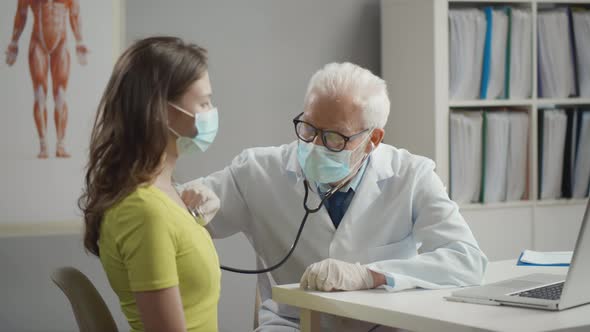 Doctor Using Stethoscope Examining Patient Wearing Masks Looking for Covid-19 Coronavirus Symptoms