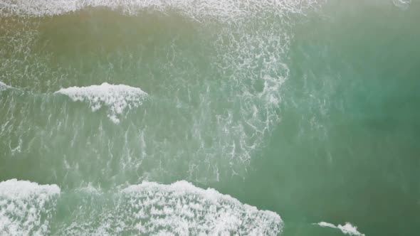 Waves breaking along Wrightsville beach Tracking aerial shot