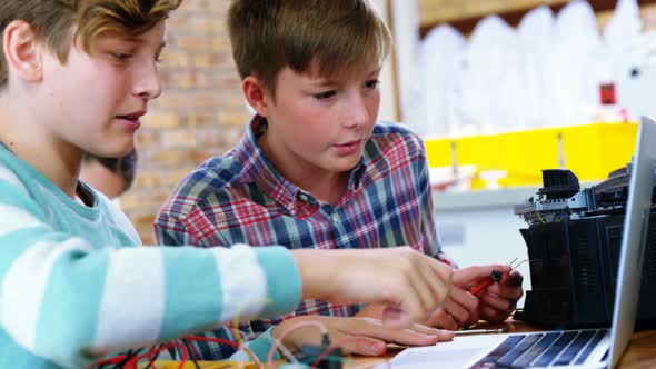 Schoolboys working on electronical project in classroom