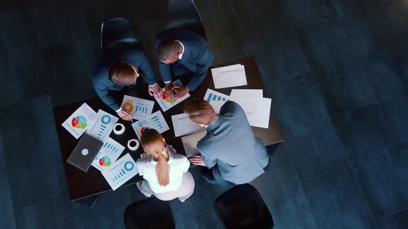 Group of business people working on a project at a table in a loft