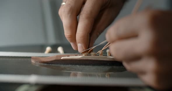 Guitar Tech Takes Off the Old Strings From the Guitar Luthier Restrings the Guitar Changing the