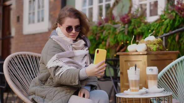 Traveller Woman in Sunglasses Does Selfie in the Street Cafe of Old Town in Autumn  60p Slow Motion