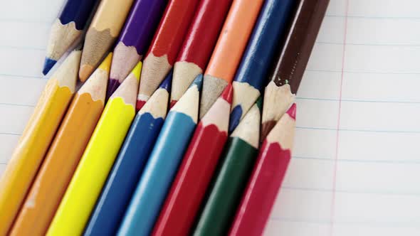 Colored pencils arranged in interlock pattern on white background