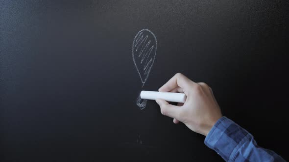 Male hand draws exclamation mark on chalkboard