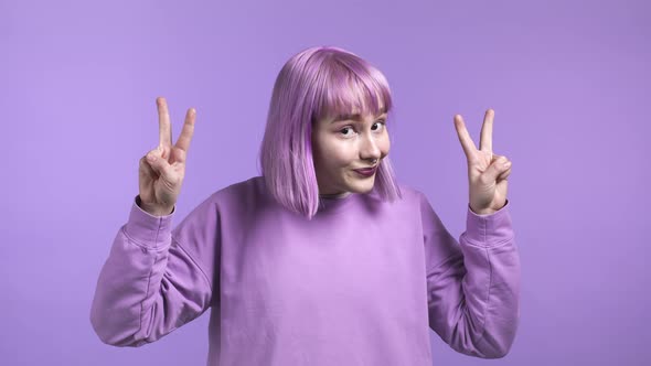 Pretty Woman with Dyed Purple Hair Showing with Hands and Two Fingers Air Quotes Gesture Bend