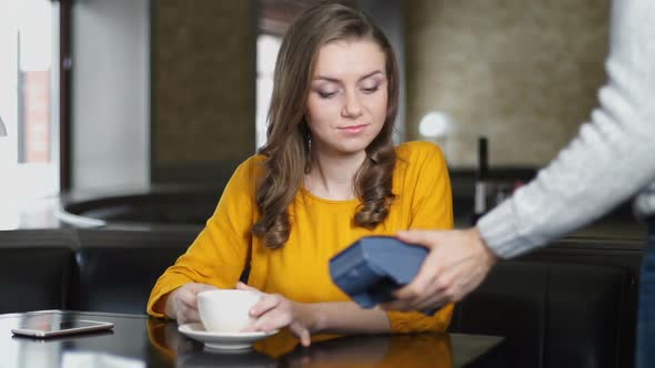 Woman Paying Cafe Bill With Credit Card Through PIN Pad, Contact Less Payment