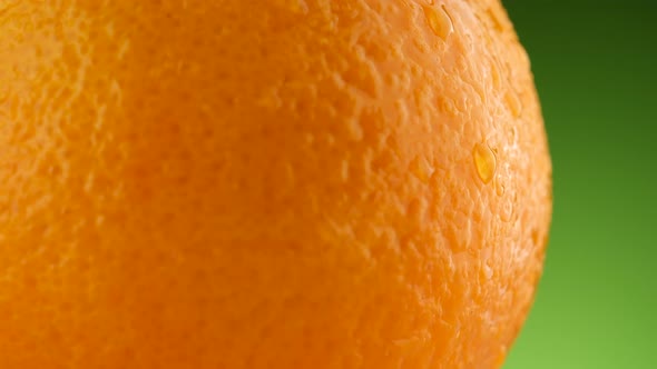 Fresh Orange fruit on green background macro, rotation.