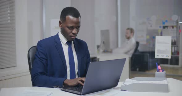 Young Afro-american Journalist Writing an Article