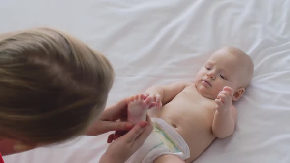 A Woman Massaging Baby Girl's Foot and Playing with Her