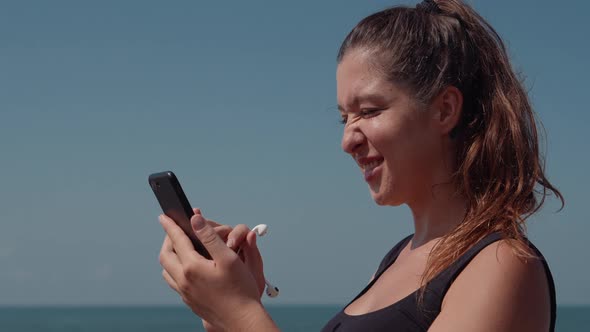 Highspirited Woman Choosing Music on Mobile Before Jog