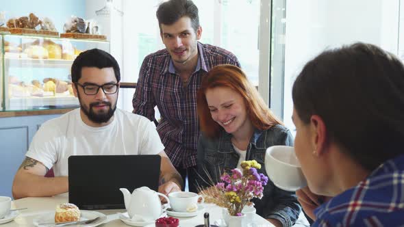 Happy Young Friends Laughing, Enjoying Having Coffee Together