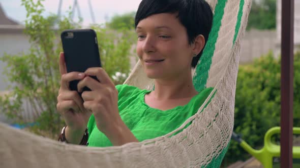 Girl Texting on Smart Phone in the Courtyard