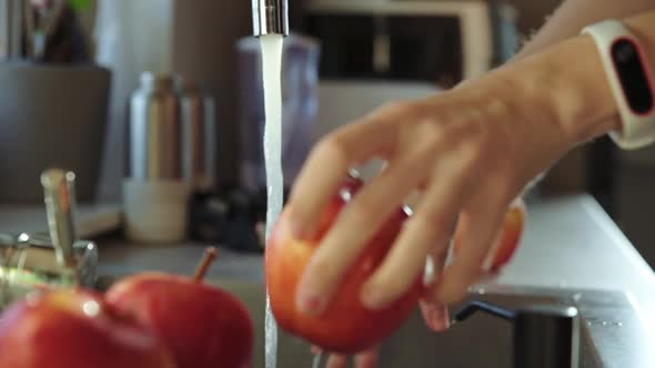 Woman Washing Red Apple in Kitchen Sink