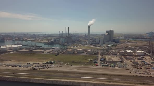 Tower with smoke in industrial harbor of Rotterdam in the Netherlands, Aerial