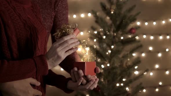 Couple Open Christmas Gift With Shiny Lights