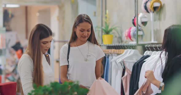 Cute Girls are Looking at Clothes in a Clothing Store