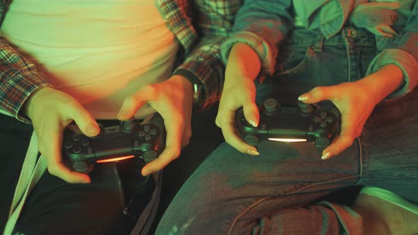 Hands of a Man and Girl Holding a Joysticks to Play Video Games on TV