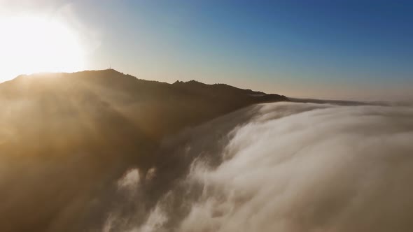 Drone flies over clouds and the top of the mountain in Malibu Canyon, Calabasas, California, USA